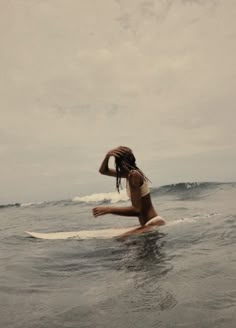 a woman sitting on a surfboard in the ocean