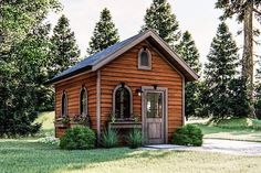 a small wooden building with a porch and windows on the front, surrounded by trees