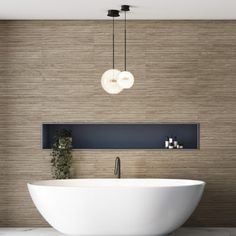 a large white bath tub sitting next to a wall mounted light above it's head