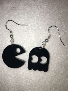 two black earrings with white letters on them