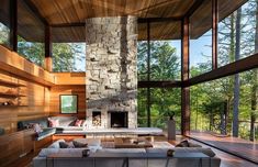 a living room filled with furniture and a fire place in front of a large window