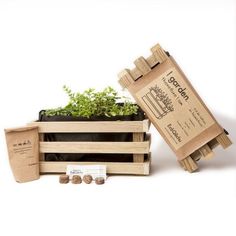 a wooden crate with plants in it next to some seed packets