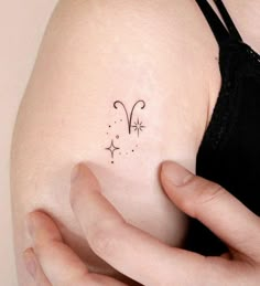 a woman's arm with a small tattoo on the back of her left shoulder