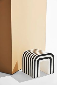 three black and white stools sitting next to each other in front of a wall