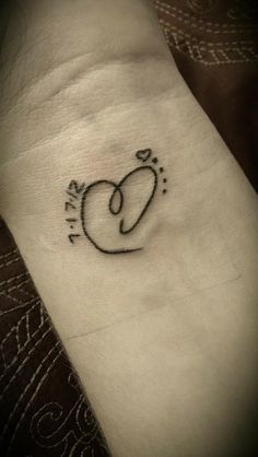 a small heart tattoo on the wrist