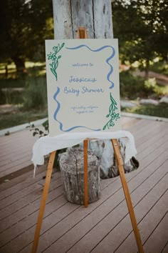 a sign that is on top of a wooden easel in front of a tree