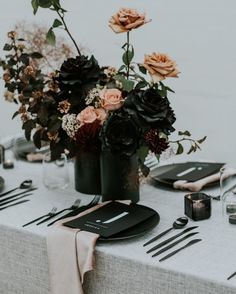 the table is set with black and pink flowers