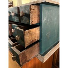 an old wooden dresser with drawers and knobs on the bottom drawer is painted teal green