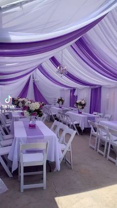 the tables are covered with purple and white draping