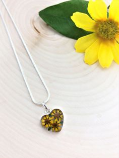 "Sunflowers: Adoration, Happiness, Wealth, and Longevity. Sunflowers are the happiest of flowers! This beautiful Sterling Silver Pendant is handmade with real sunflowers. These flowers are specifically grown to be miniature. They preserve their natural blooming colors and fresh look because of a special drying process. These adorable sunflowers are preserved in resin and encased in Sterling Silver .925. This pendant comes with a FREE Silver Plated Chain. Choose the chain length that you like! ke Mother's Day Flower Shaped Jewelry With Heart Charm, Mother's Day Flower Jewelry With Heart Charm, Mother's Day Jewelry With Heart Charm And Flower Shape, Yellow Flower Jewelry For Mother's Day, Mother's Day Flower Necklaces With Heart Charm, Mother's Day Flower Necklace With Heart Charm, Mother's Day Necklaces With Heart Charm And Flower Shape, Flower Shaped Necklace For Valentine's Day, Yellow Flower Necklaces With Birth Flower Detail