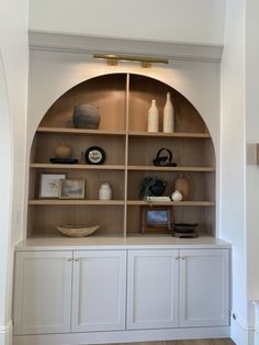 an arched shelf with vases and other items on it