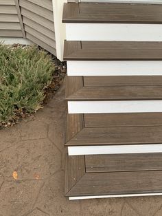 the corner of a house with siding on it's side and grass growing next to it