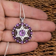 "The exquisite jewelry, made out of high-quality 925 sterling silver, inlaid with natural big amethyst and white cubic zirconia crystals has exceptional sacred meaning The pendant combines the Star of David made out of sterling and the 12 amethyst gemstones. The Star of David hexagram has been known to mankind since ancient times. The first products depicting Magen David were discovered during excavations in Sidon. The six rays of the star symbolize that God rules the world and protects us from Silver Star Of David Necklace With Gemstone, Star Of David Necklace In Cubic Zirconia As Gift, Silver Cubic Zirconia Star Of David Jewelry, Sterling Silver Star Of David Fine Jewelry Necklace, Silver Star Of David Fine Necklace, Fine Sterling Silver Star Of David Jewelry, Fine Jewelry Sterling Silver Star Of David, God Rules, Necklace Women Silver