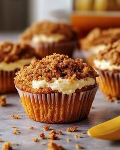 several cupcakes with white frosting and crumbs