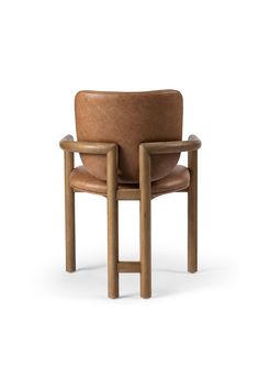 a brown chair sitting on top of a white floor next to a wooden armrest