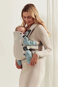 a woman holding a baby in a sling