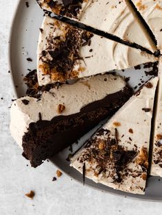 a white plate topped with a cake covered in frosting and chocolate shavings