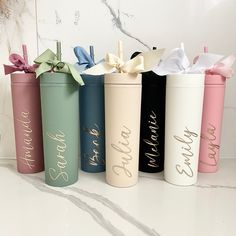 four different colored canisters with bows on them sitting on a counter top next to each other