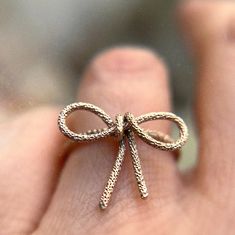 Sparkle Bow Ring - Available in Gold Filled or Sterling Silver Adorn your finger with the whimsy of the Sparkle Bow Ring. Available in gold filled for warmth and luster or in sterling silver for its bright and timeless elegance, this ring is the epitome of playful sophistication. The intricate bow is a classic symbol of celebration and individuality, with each handcrafted loop and twist catching the light, creating a dazzling display. Measuring delicately in size, it offers a charming statement Elegant Nickel-free Gold Rings, Nickel-free Gold Jewelry For Promise Ring, Elegant Nickel-free 14k Gold Rings, Elegant Nickel-free Yellow Gold Rings, Gold Sterling Silver Rings For Gift, Nickel Free Yellow Gold Wedding Ring, Unique Hypoallergenic Gold Jewelry, Rose Gold Metal Ring Jewelry As Gift, Gold Jewelry For Promise Ring