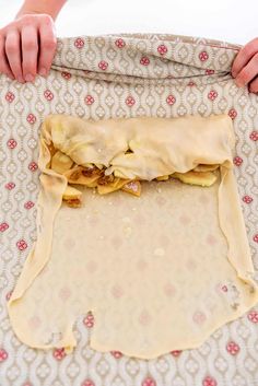 a person is making food on top of a mat with their hands over the mat