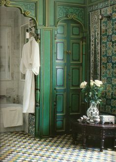 an ornately decorated bathroom with green and white tiles on the floor, walls and ceiling