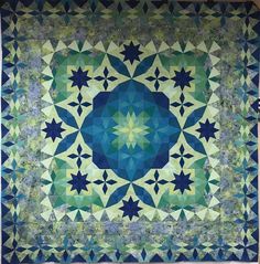 a blue and green quilt with stars on it