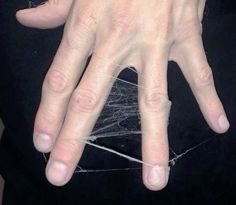 a person's hand with spider web on it