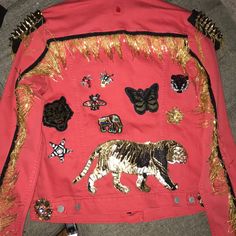 a pink jacket with gold sequins and tiger patches