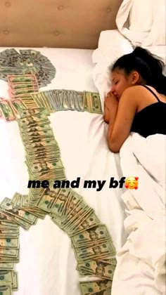 a woman laying in bed with her head on the pillow while she sleeps next to money