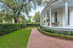 a white house with a brick walkway leading to the front door and side yard area