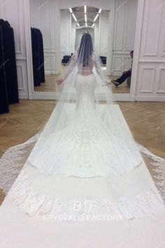 a woman in a wedding dress is walking down the aisle with her veil over her head