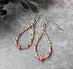 These earrings are crafted using peach colored and silver tone beads. Earrings measure approximately 2". Brown Dangle Beaded Earrings For Summer, Brown Dangle Beaded Earrings With Colorful Beads, Pink Sterling Silver Beaded Earrings, Coral Beaded Drop Earrings, Pink Artisan Earrings With Dangling Beads, Handmade Peach Dangle Earrings, Nickel-free Orange Beaded Dangle Earrings, Beaded Drop Earrings, Etsy Earrings Dangle