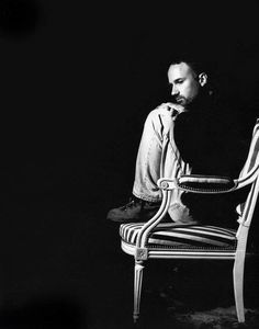 a black and white photo of a man sitting on a chair