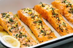 salmon fillets in a baking dish with lemon wedges