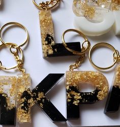 This handmade keychain is crafted with epoxy resin and gold foil flakes, creating a glamorous yet durable accent. Each letter is 1.5” tall and comes with gold hardware, with options for silver or rose gold. Each keychain is unique and custom-made, with small air bubbles and other slight imperfections possible. Shop our selection to find your favorite! hesitate to reach out. We have other keychain colors and designs available in the shop check them out to find your favorite! All keychains are make upon ordering take 3 days to make Epoxy Letter Keychains, Letter Keychain Resin, Letter Resin Keychain, Resin Letter Keychain, Diy Resin Keychain, Resin Pendant Diy, Keychain Resin, Keychain Black, Letter Keychain