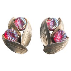 A pair of Elsa Schiaparelli 1940s clip earrings. Each earring has three goldtone leaves and two ruby tone textured jewels. Elsa Schiaparelli, Jeweled Earrings, Ceramic Jewelry, Clip Earrings, Jewelry Creation, Clip On Earrings, Ruby, Gold Tones, Jewelry Earrings