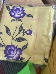 there is a yellow bag with purple flowers on it