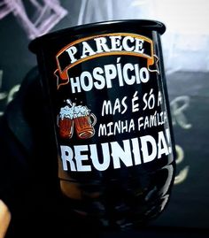 a person holding up a plastic cup with beer on the inside and writing in spanish