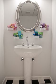 a white sink sitting under a mirror in a bathroom