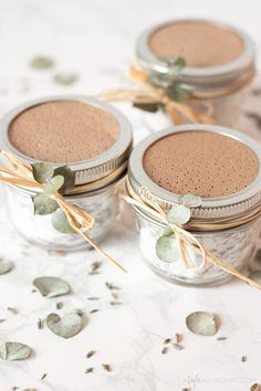 three glass jars filled with different types of brown stuff on top of a white table