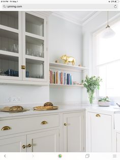 a kitchen with white cabinets and gold pulls on the cupboards is featured in an instagram