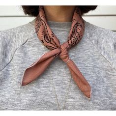 a woman wearing a pink scarf with an intricate design on the front and back of her neck