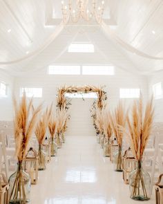 the aisle is lined with clear glass vases filled with flowers and pamodia