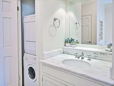 a washer and dryer in a white bathroom