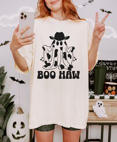 Get ready to spook up some fun with our Boo Haw Shirt! Made from 100% cotton, this adorable ghost tee is perfect for Halloween. With a playful Boohaw design, this shirt will add a touch of fun to your spooky festivities. Specifications: Brand: Comfort Colors Neckline: Crew Neck Fit: Unisex Color: ivory Material: 100% US Ring Spun Cotton Sizing recommendation: For a more fitted look, it is recommended to size down one size. Stay with your true size for a relaxed fit. Size up one or two sizes for White Funny Text T-shirt For Fall, Fun White T-shirt For Halloween, Fun White Halloween T-shirt, Funny White T-shirt For Fall, Funny White Shirt For Fall, Toddler Basketball, Softball Tees, Soccer Tees, Thanksgiving Tee