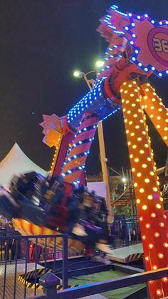 an amusement park ride at night with lights on it