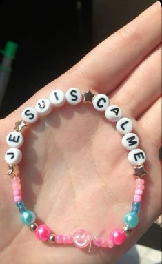 a hand holding a bracelet with words on it that say sustenance and hearts