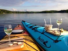 two kayaks with drinks on the side of them