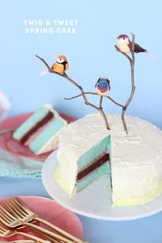 three birds are perched on the branches of a cake