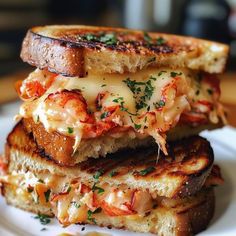 two grilled sandwiches stacked on top of each other with melted cheese and toppings